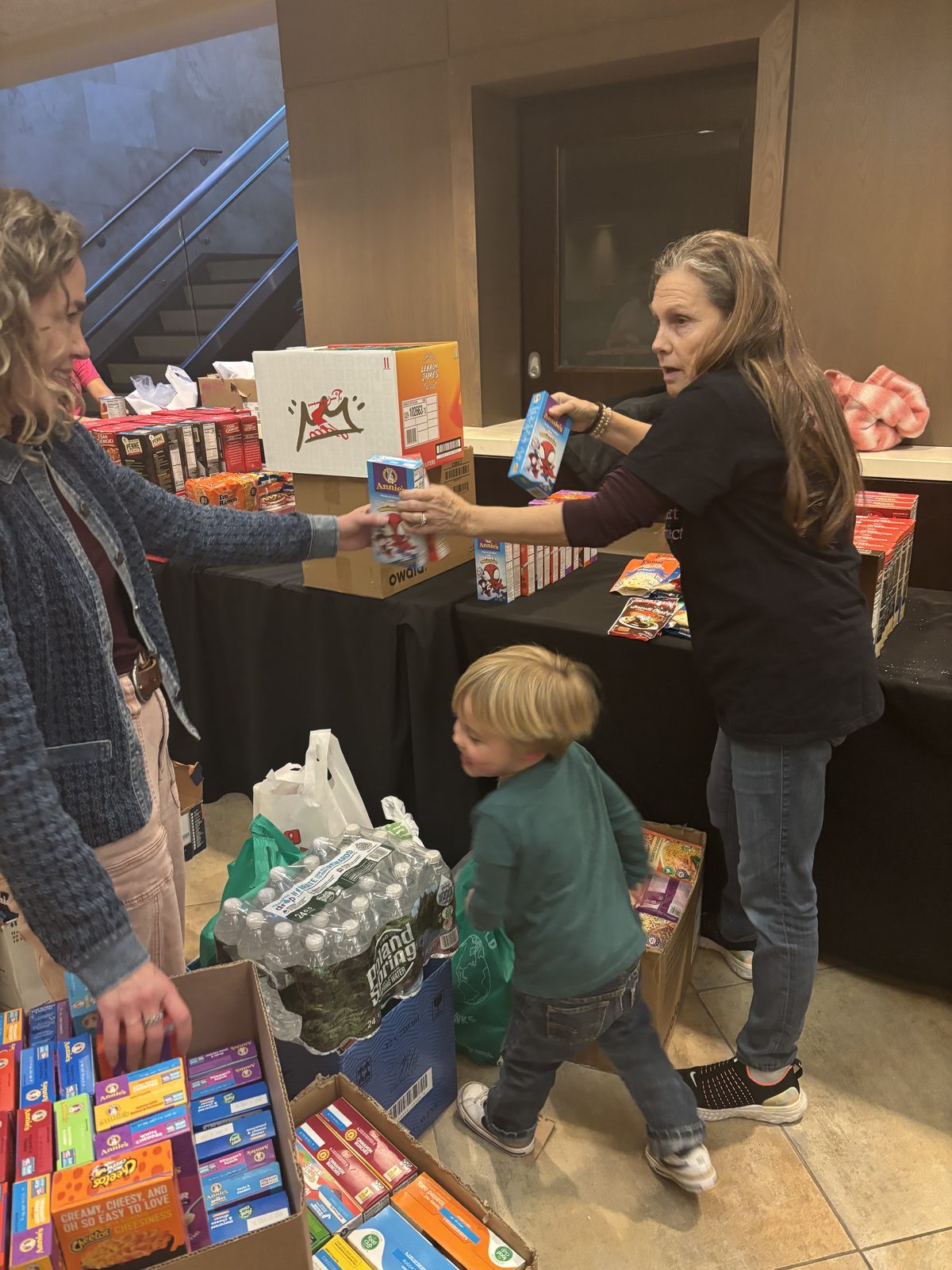 Adults and youth pack and sort boxes of supplies together.