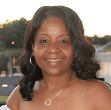 Shanneikqua Tolliver smiles in a warm outdoor portrait at golden hour.